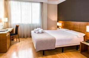 a hotel room with a large bed and a desk at Zenit Logroño in Logroño