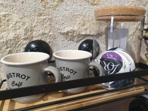 two coffee mugs sitting on a shelf with weights at Le duplex du 71 B in Niort