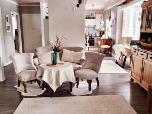 a living room with a table and chairs at RoseGarden - art&nature - talo luonnossa in Espoo