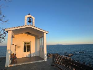 eine kleine Kapelle am Ufer eines Wasserkörpers in der Unterkunft Mykonos Seaside Villa in Paralía Avdhíron