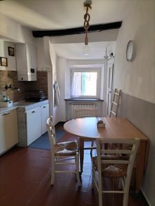 une cuisine avec une table et des chaises dans une cuisine dans l'établissement I Monti sul Mare - appartamento a Genova Pegli, à Gênes