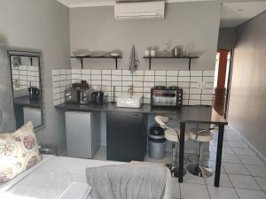 a kitchen with a counter and a table in a room at A47 self catering apartment inside Bains Lodge in Bloemfontein