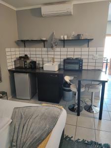 a kitchen with a table and a counter top at A47 self catering apartment inside Bains Lodge in Bloemfontein +7 photos