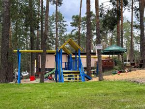 a playground with a slide in a park with trees at Bungalov Elite in Staré Splavy