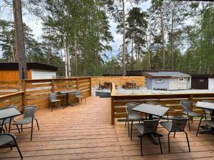 a deck with tables and chairs and a cabin at Bungalov Elite in Staré Splavy