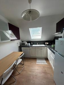 eine Küche mit Holztisch und Kühlschrank in der Unterkunft CHAMBRE FamilIale in Nandy