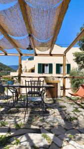 a patio with a table and chairs under a pergola at Cà Eucalipto in Finale Ligure