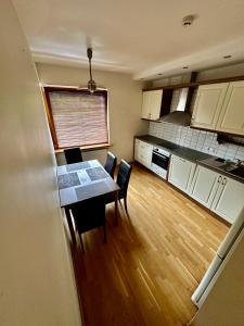 a kitchen with a table and chairs in a room at Vingis Park Apartments with 2 Bedrooms & Free Parking in Vilnius +8 photos