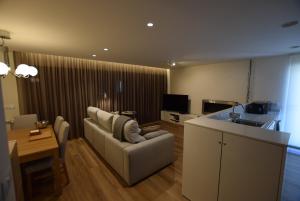 a living room with a couch and a table and a kitchen at Marinhas Nature in Marinhas