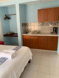 two beds in a room with a kitchen at Departamentos privados In Wotoch in Valladolid