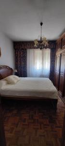 a bedroom with a large bed with a chandelier at Casa-Nieves in Santa Cristina +20 photos