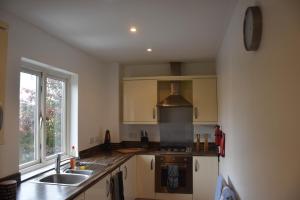 a kitchen with a sink and a stove and a window at Luxurious & Spacious 2 bed Apartment in Milton Keynes in Milton Keynes