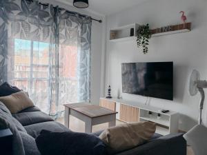 a living room with a couch and a tv at Las Palmeras in Matalascañas