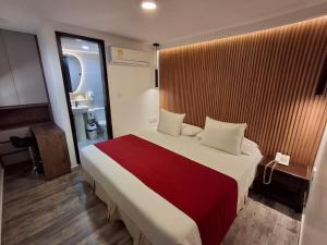 a bedroom with a large bed with a red blanket at Hotel León Dorado in Bucaramanga +36 photos