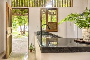 cocina con encimera con fregadero y espejo en apartamento ravenala, en Trancoso