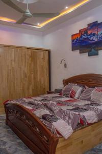 コトヌーにあるRAWADE Guest houseのベッドルーム1室(大型木製ベッド1台付)