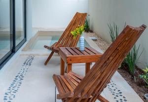 two wooden chairs and a table on a patio at New luxury studio with plunge pool in Tulum
