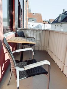 einen Balkon mit 2 Stühlen, einem Tisch und einem Tisch in der Unterkunft Schiller-Quartier 15 in Bremerhaven