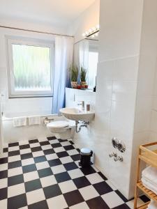 ein Badezimmer mit Waschbecken und Toilette und einem Schachbrettboden in der Unterkunft Schiller-Quartier 15 in Bremerhaven + 65 Fotos