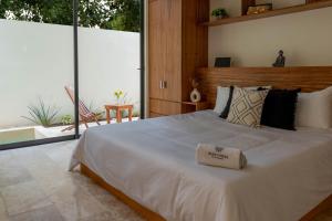 a bedroom with a large white bed and a large window at New luxury studio with plunge pool in Tulum