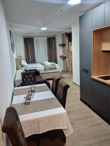 a room with a dining table and a bedroom at Lela Kop in Kopaonik