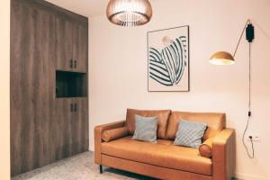 a living room with a brown couch in front of a door at Séjour Chic et Cosy au Cœur de Versailles in Versailles