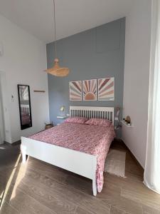 a bedroom with a white bed with a red comforter at Maison Comì in Frattamaggiore