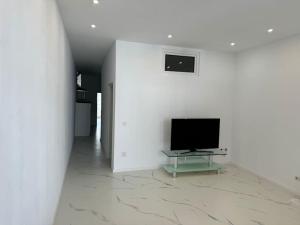 a living room with a tv and a white wall at Gemütliche Wohnung in Heilbronn in Heilbronn