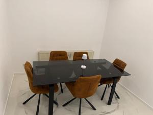 a black dining room table with brown chairs at Gemütliche Wohnung in Heilbronn in Heilbronn +5 photos
