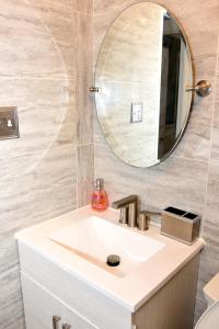 a bathroom with a white sink and a mirror at Handsome Home Renovated - close to Metro in Lanham +44 photos