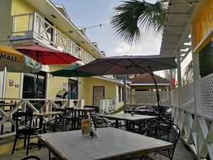 an outdoor patio with tables and chairs and umbrellas at Sun Fun Hotel in Nassau