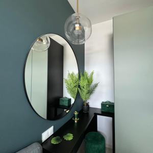 a room with a mirror and a table with a plant at Apartament Smolna Sun in Szeląg