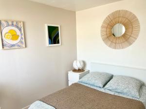 a bedroom with a bed and a mirror on the wall at Appartement les Falaises in Cap d'Agde