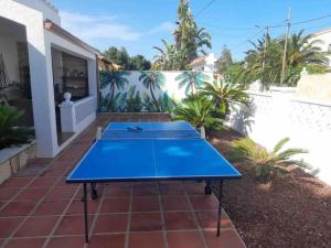 un tavolo da ping pong blu su un patio di Villa las palmeras bonita casa con piscina privada a Les tres Cales