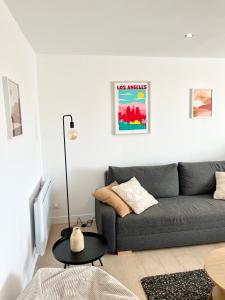 a living room with a gray couch and a table at Appartement les Falaises in Cap d'Agde