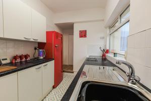 a kitchen with a sink and a red refrigerator at Londonderry House in Stockton-on-Tees +27 photos