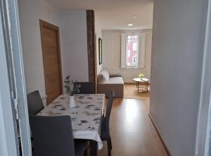 a dining room with a table and chairs and a living room at La Casona Santander Centro in Santander