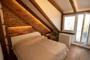 Un dormitorio con una cama y una pared de ladrillo. en Mezonetový apartmán 2 u rybníka, en Olomouc