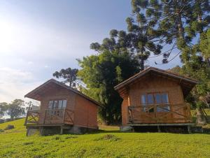 two small buildings sitting on top of a hill at Solar dos Pinhais in Santo Antônio do Pinhal