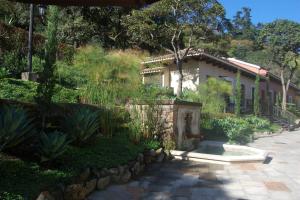 a house with a garden in front of it at La Villa de que buscabas en Antigua Guatemala in Antigua Guatemala