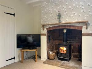 a living room with a brick fireplace with a stove at Stone Hill Farm B&B in Shrawley