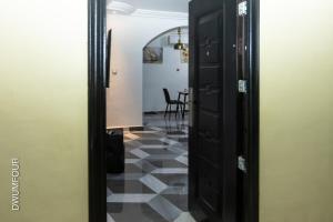 a hallway with a black door and a checkered floor at Caroline Cozy Apartment in Accra