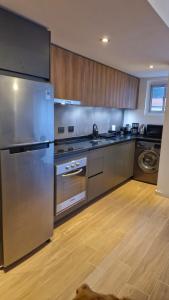 a kitchen with stainless steel appliances and a dog laying on the floor at Moderno y funcional in Mar del Plata +4 photos
