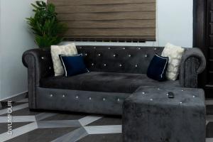 アクラにあるCaroline Apartmentのリビングルームにある、枕とテーブルが付いた革張りのソファ +84枚の写真