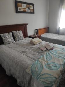 a bedroom with two beds with towels on them at Casa Lúcia in Nazaré