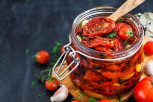 a jar of food with tomatoes and a wooden spoon at La casa di Biu in Gela