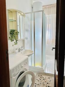 un bagno con lavatrice e lavandino di La casa di Biu a Gela