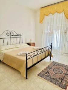 a bedroom with a large bed and a rug at La casa di Biu in Gela