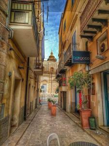 un vicolo con edifici e piante in vaso di La casa di Biu a Gela Altre 13 foto