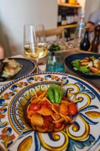 un piatto di cibo su un tavolo con un bicchiere di vino di La casa di Biu a Gela